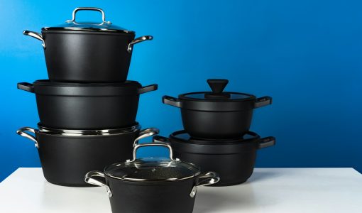 Set of black cookware against blue background